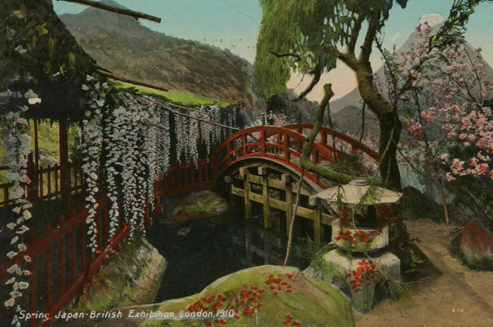 A postcard depicting a red bridge over a pond with trees and cherry blossoms surrounding it and a mountain in the background.