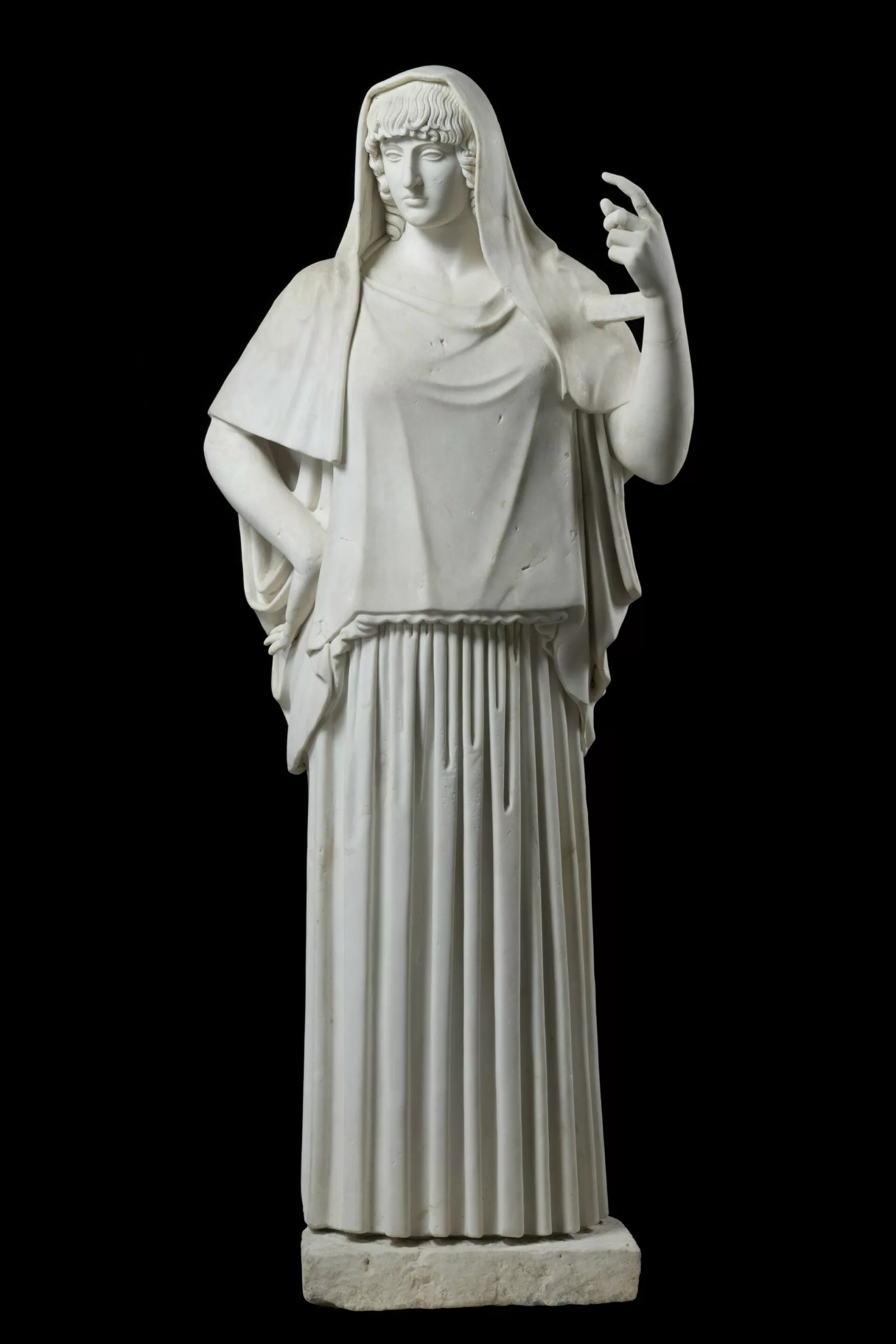 A marble statue of a woman with her left arm raised.